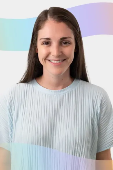 A woman with long brown hair smiles at the camera. She is wearing a light blue pleated blouse. The background features a wavy, pastel rainbow design.