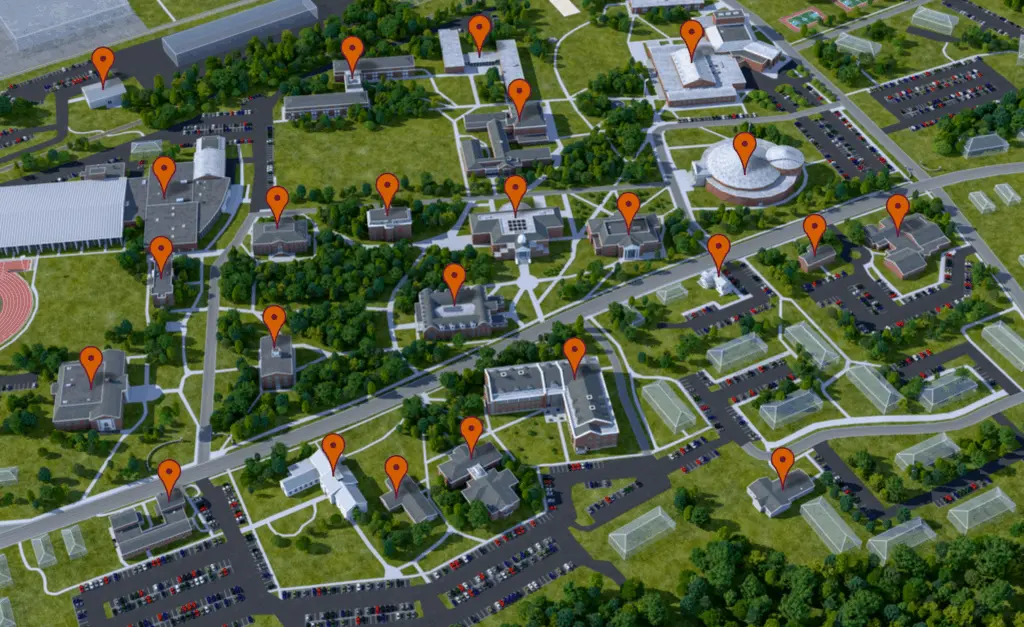 Aerial view of a campus with multiple buildings. Orange location pins are placed on top of various structures. Paths, roads, parking lots, and greenery are visible throughout the scene.