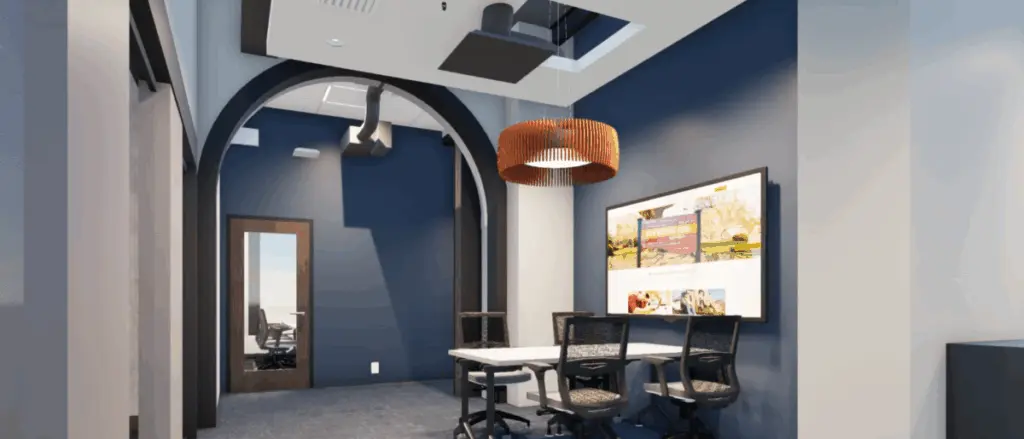 A modern office space in Building and Spaces style, featuring navy blue walls, a white table, three black chairs, a large monitor displaying images, and a wooden pendant light. An arched doorway leads to another area.