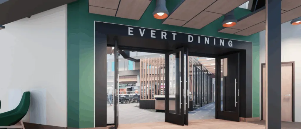 Entrance to a modern dining hall named “Evert Dining,” part of the Building and Spaces initiative, with large glass double doors, green and white walls, and contemporary ceiling lights. Inside, tables and chairs are visible through the open doorway.