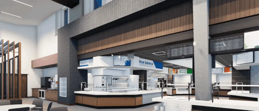 Modern cafeteria interior with multiple food stations, clean white countertops, and geometric accents showcases exceptional Building and Spaces design, featuring overhead signs and a spacious, well-lit layout with sleek finishes.